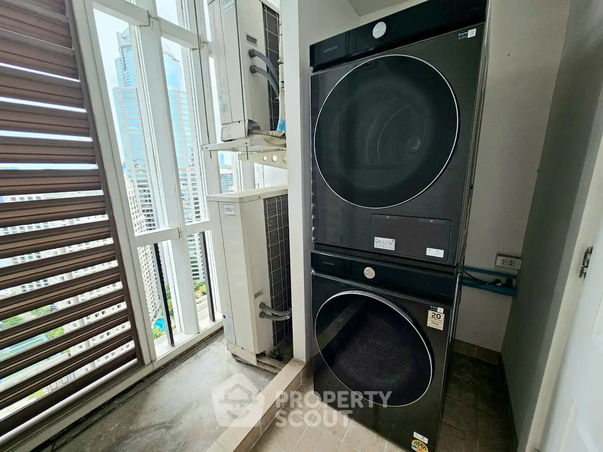 Modern laundry area with stacked washer and dryer in high-rise apartment with city view.