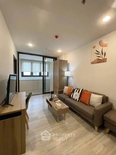 Modern living room with stylish decor and natural light, featuring a cozy sofa and sleek wooden furniture.