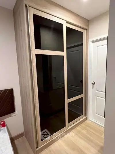 Modern bedroom with sleek built-in wardrobe and elegant wooden flooring.