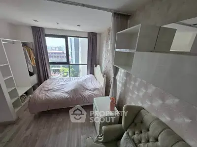 Cozy bedroom with modern decor and city view, featuring a comfortable bed and ample storage.