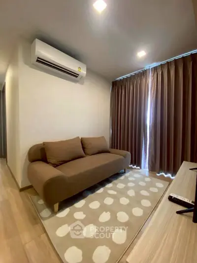 Cozy living room with modern sofa and air conditioning, perfect for relaxation.