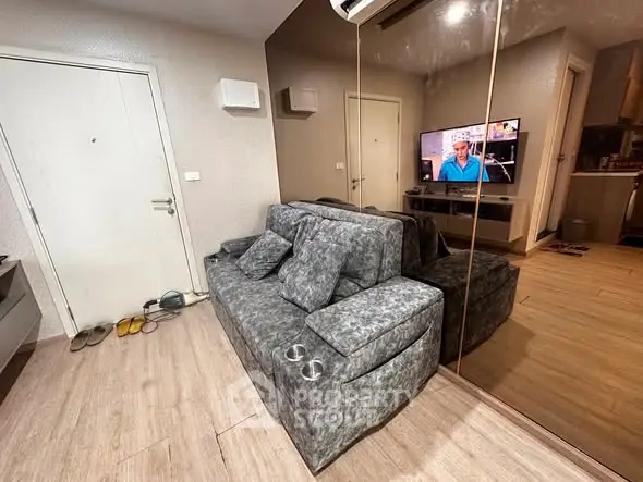 Modern living room with stylish gray sofa and wall-mounted TV, reflecting a cozy and inviting atmosphere.