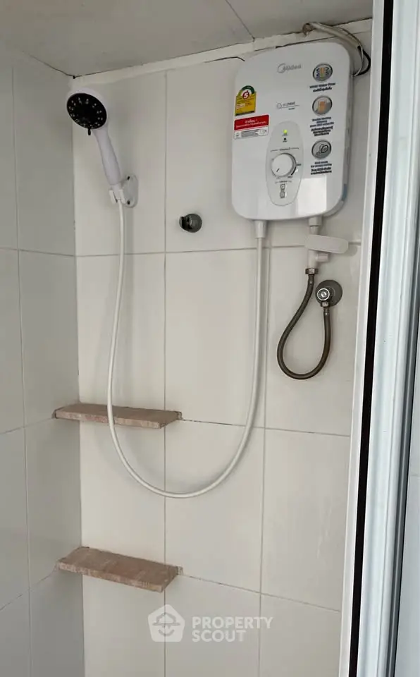Modern bathroom shower with electric water heater and tiled walls