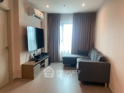 Modern living room with sleek furniture and large TV, perfect for relaxation.
