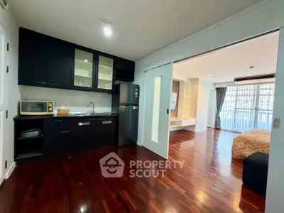 Spacious open-layout kitchen and living area with hardwood floors and modern appliances.