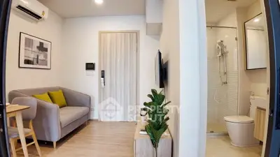 Modern compact living room with cozy sofa and bathroom access, ideal for urban living.