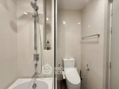Modern bathroom with sleek shower and toilet in a minimalist design.