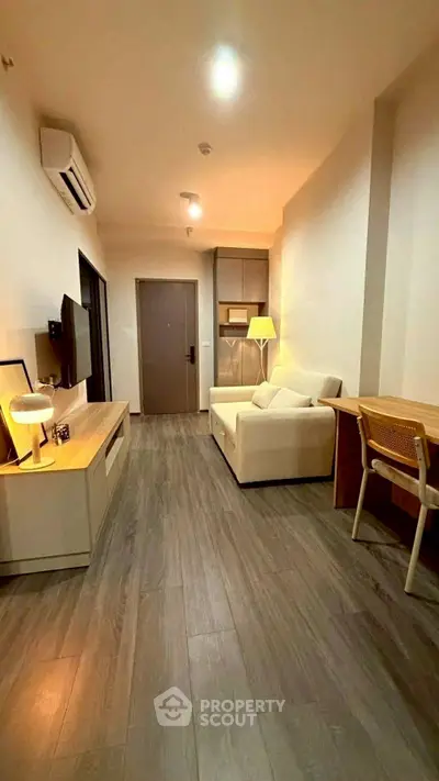 Modern living room with sleek wooden flooring, cozy sofa, and stylish decor in a contemporary apartment.