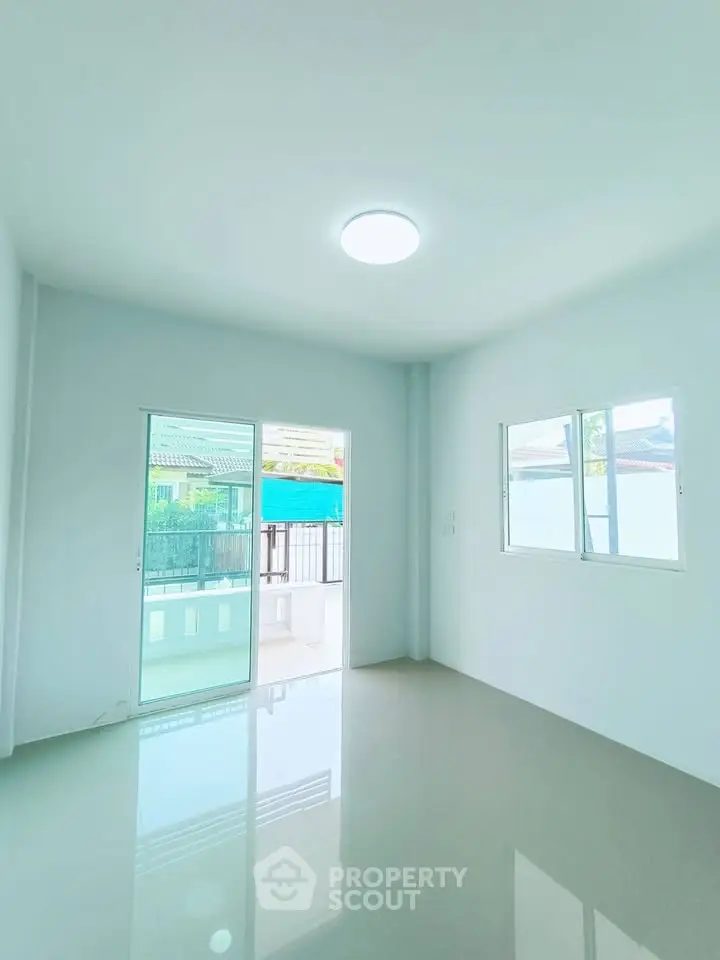 Bright and airy living room with large windows and balcony access, perfect for natural light lovers.