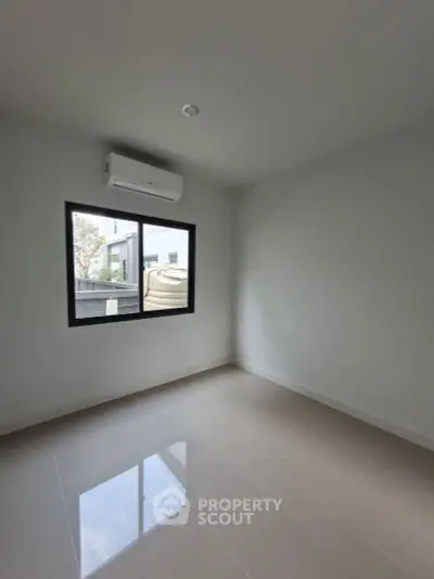 Bright empty room with air conditioning and large window in modern home.