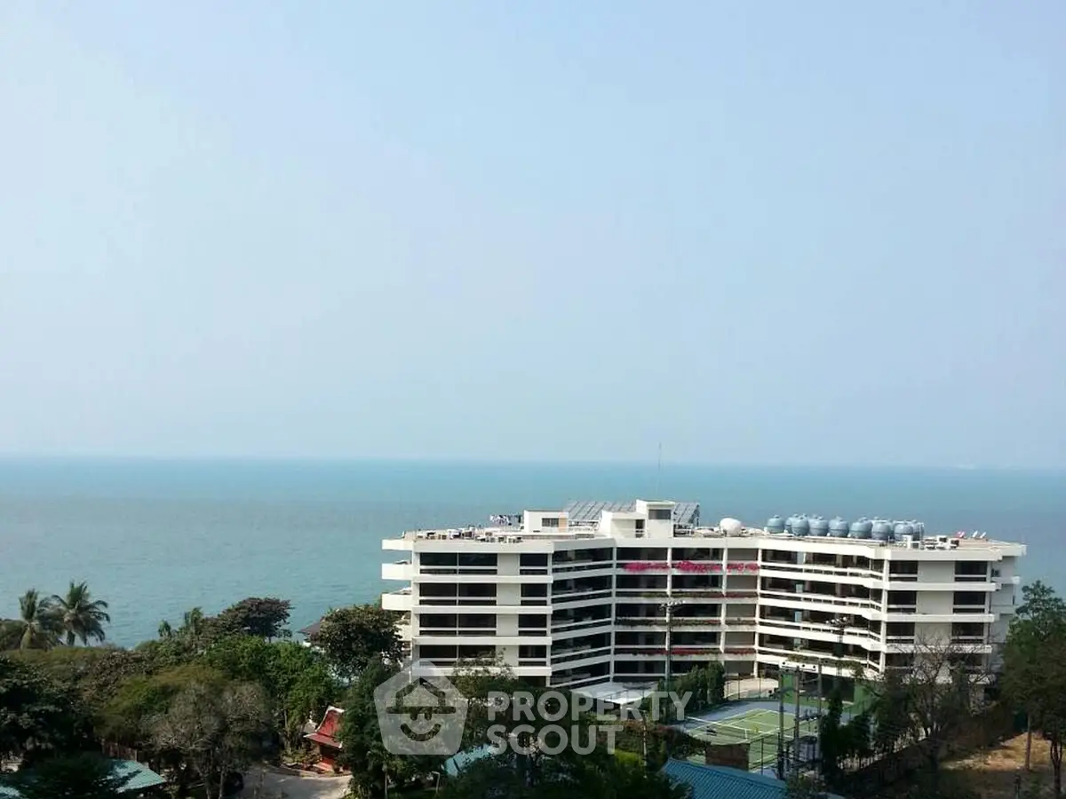 Stunning oceanfront apartment building with panoramic sea views and lush surroundings.