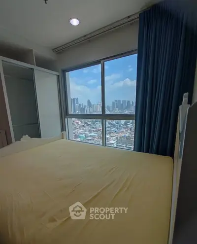 Cozy bedroom with city view, featuring large window and elegant curtains, perfect for urban living.