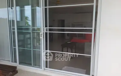 Spacious modern living room with sliding glass doors and open kitchen layout.