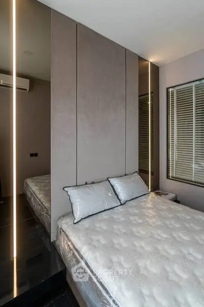 Modern bedroom with sleek design and stylish decor, featuring a comfortable bed and ambient lighting.