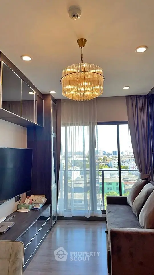 Modern living room with elegant chandelier and city view balcony