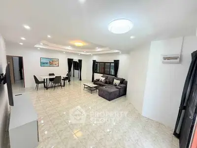 Spacious modern living room with elegant dining area and cozy seating, ideal for family gatherings.