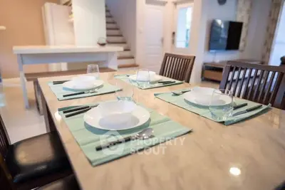 Elegant dining area with modern table setting in a stylish open-plan home interior.