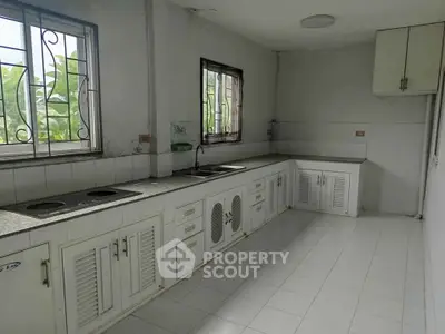 Spacious kitchen with ample counter space and natural light, perfect for culinary enthusiasts.