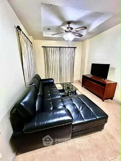 Spacious living room with leather sectional sofa and modern entertainment center.