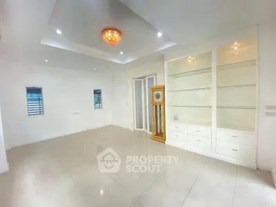 Spacious living room with elegant chandelier and built-in shelves