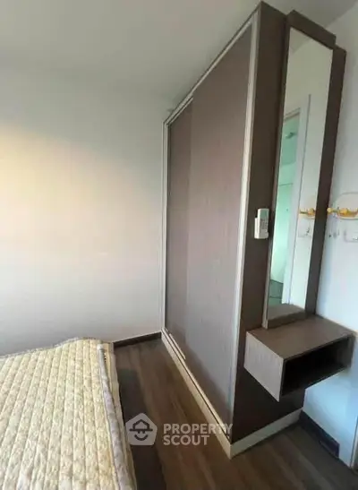 Modern bedroom with sleek wardrobe and cozy bedding in a stylish apartment.
