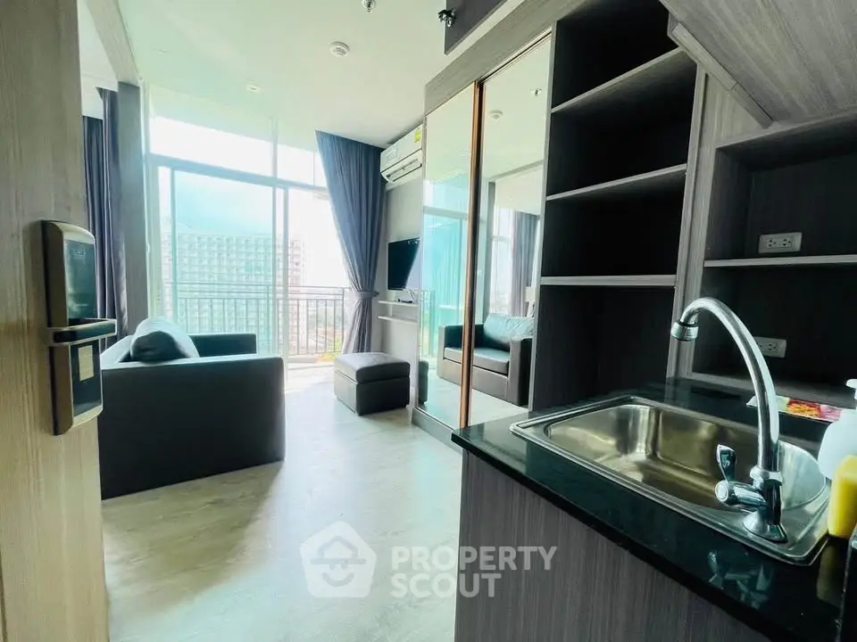 Modern living room with open kitchen and balcony view in high-rise apartment