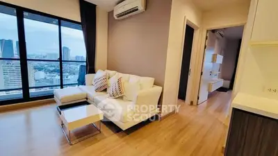 Modern living room with city view and stylish decor in high-rise apartment.