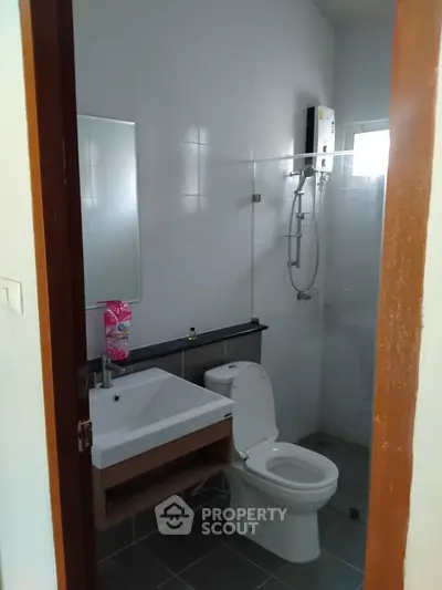 Compact modern bathroom with wall-mounted sink, toilet, and glass shower enclosure, ideal for efficient living spaces.