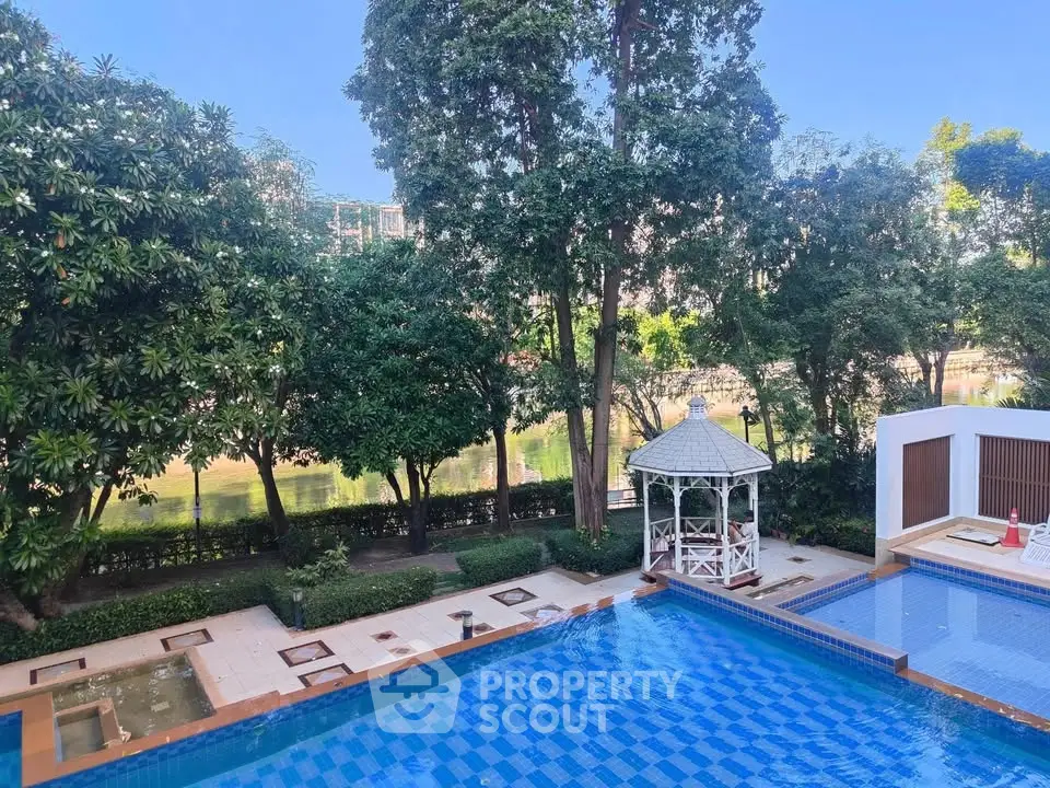 Luxurious outdoor pool area with lush greenery and elegant gazebo, perfect for relaxation and leisure.