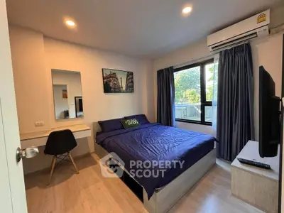 Modern bedroom with cozy bed, wall-mounted TV, and large window for natural light.