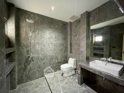 Luxurious marble bathroom with modern fixtures and spacious shower area