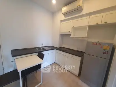 Modern kitchen with sleek countertops and compact dining area in a cozy apartment.