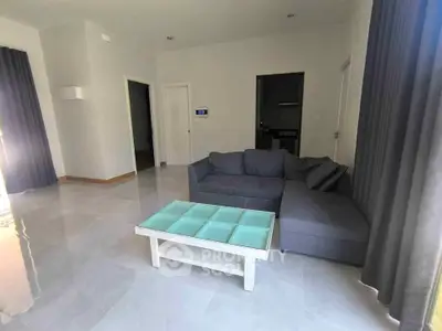 Spacious modern living room with sleek gray sofa and glass coffee table, perfect for relaxation.