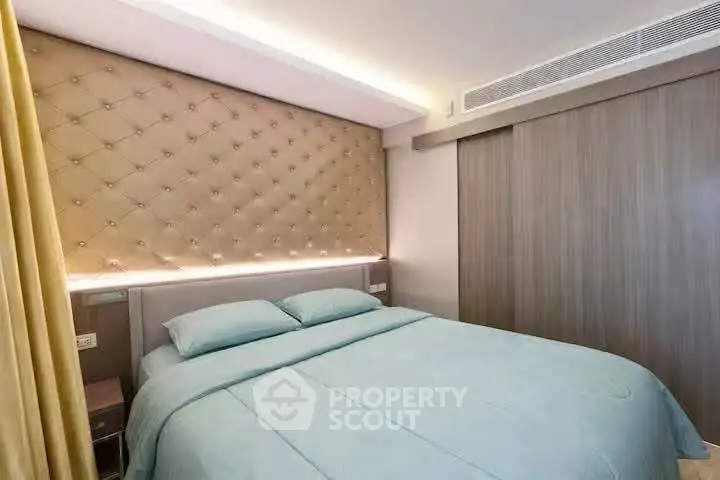 Luxurious bedroom with elegant tufted headboard and soft lighting, perfect for relaxation.
