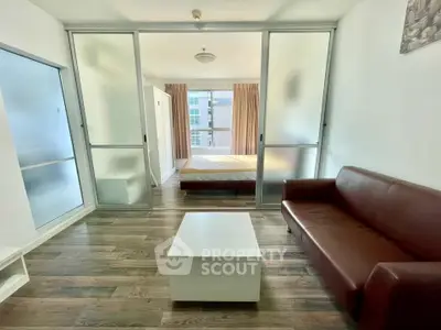 Modern studio apartment with sliding glass doors and wooden flooring
