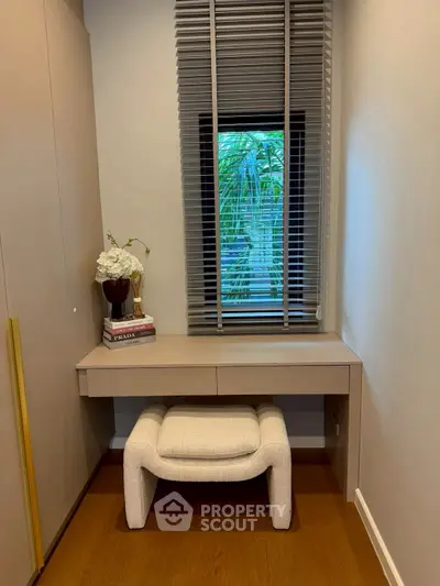 Chic study nook with modern desk, plush stool, and window view, perfect for productivity and style.