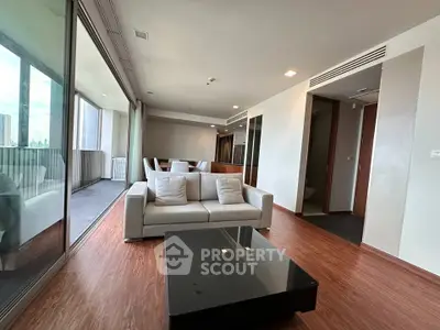 Spacious modern living room with floor-to-ceiling windows and elegant wooden flooring.