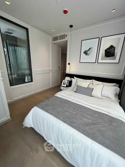 Luxurious modern bedroom with elegant decor and stylish artwork, featuring a cozy bed and sleek design.