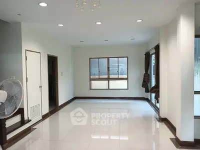 Spacious empty living room with large windows and modern lighting