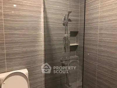 Modern bathroom with sleek shower and tiled walls, perfect for a contemporary home.