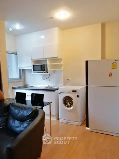 Modern compact kitchen with washing machine and fridge in cozy apartment