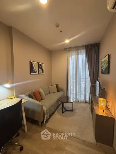 Cozy living room with modern decor, featuring a comfortable sofa, stylish artwork, and a large window for natural light.