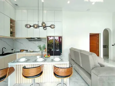 Modern open-layout kitchen and living room with stylish decor and marble finishes.