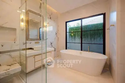 Luxurious bathroom with elegant marble finishes and a freestanding bathtub.