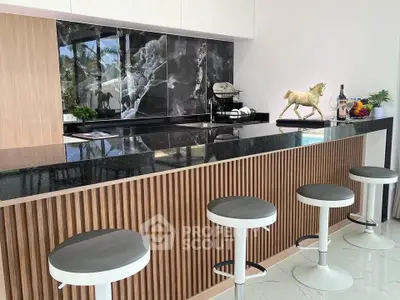 Modern kitchen with sleek black countertops and stylish bar stools