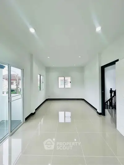 Spacious bright room with glossy tiled floor and balcony access in modern home