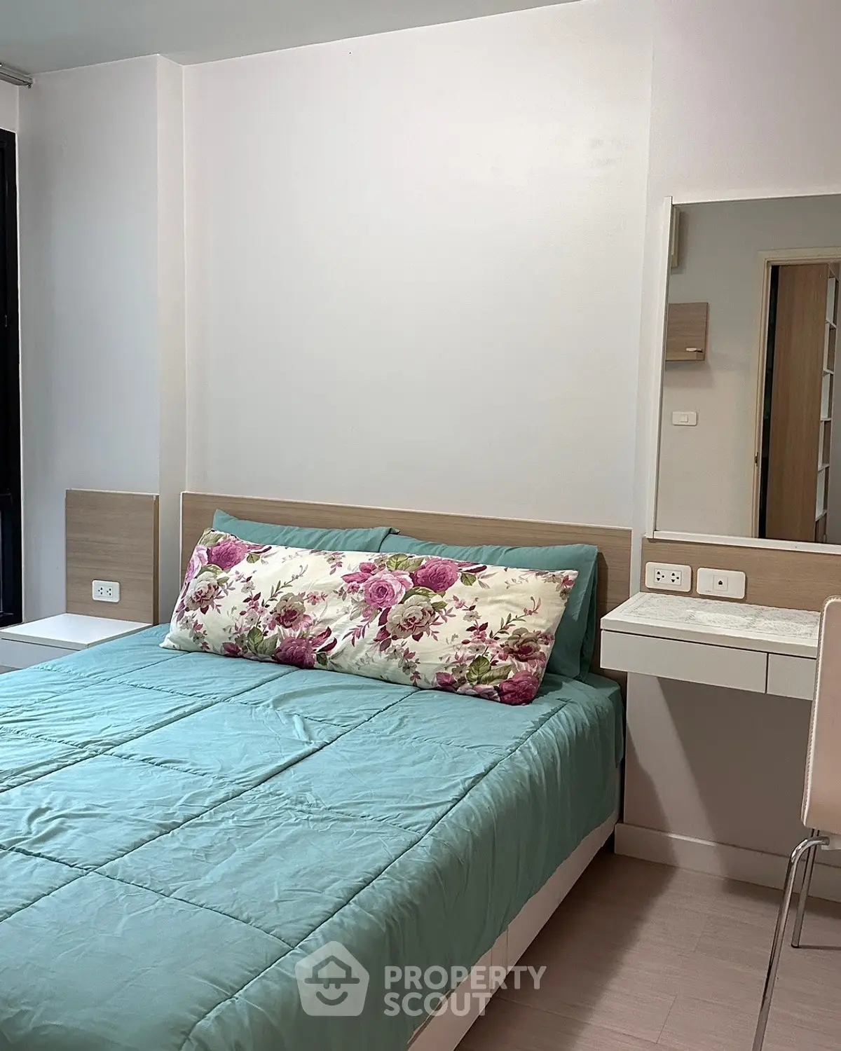 Cozy bedroom with modern decor and floral accents in a stylish apartment.