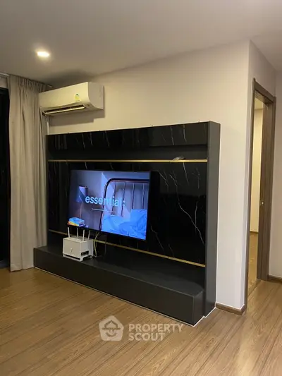 Modern living room with sleek black entertainment center and wood flooring