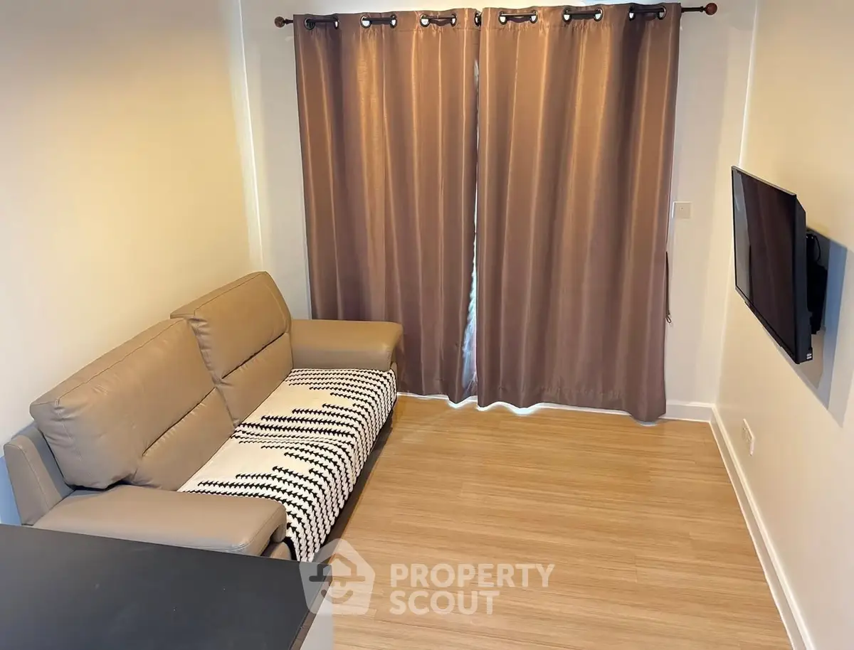 Cozy living room with modern sofa and wall-mounted TV, perfect for relaxation.