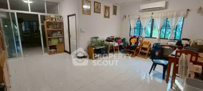 Spacious living room with tiled floor, large windows, and air conditioning, perfect for family gatherings.